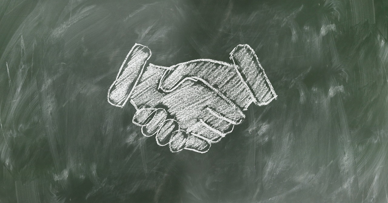Chalk designed handshake on a green whiteboard image
